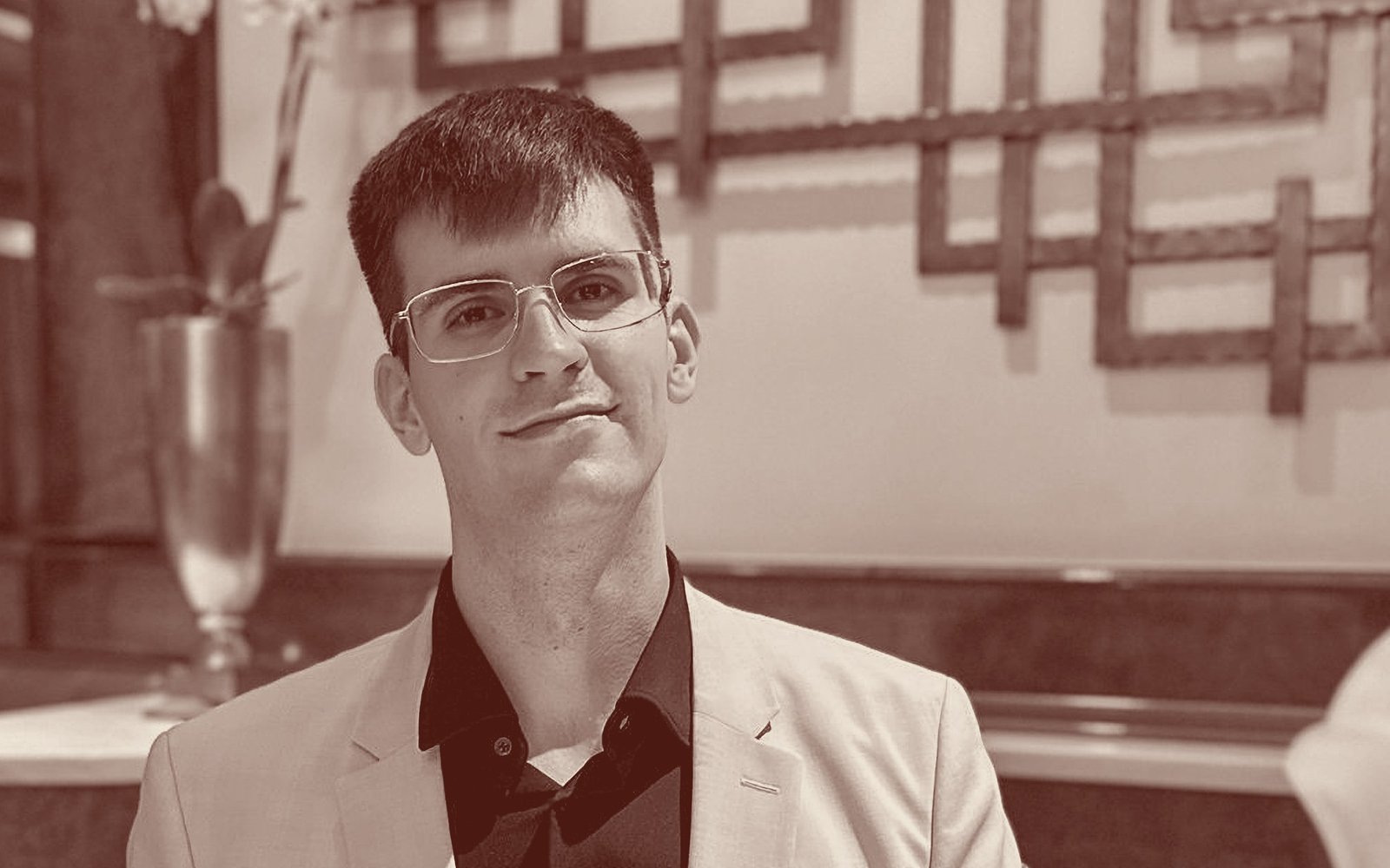 Raphael Kober sitzt in einem Wiener Kaffeehaus und blickt in die Kamera.